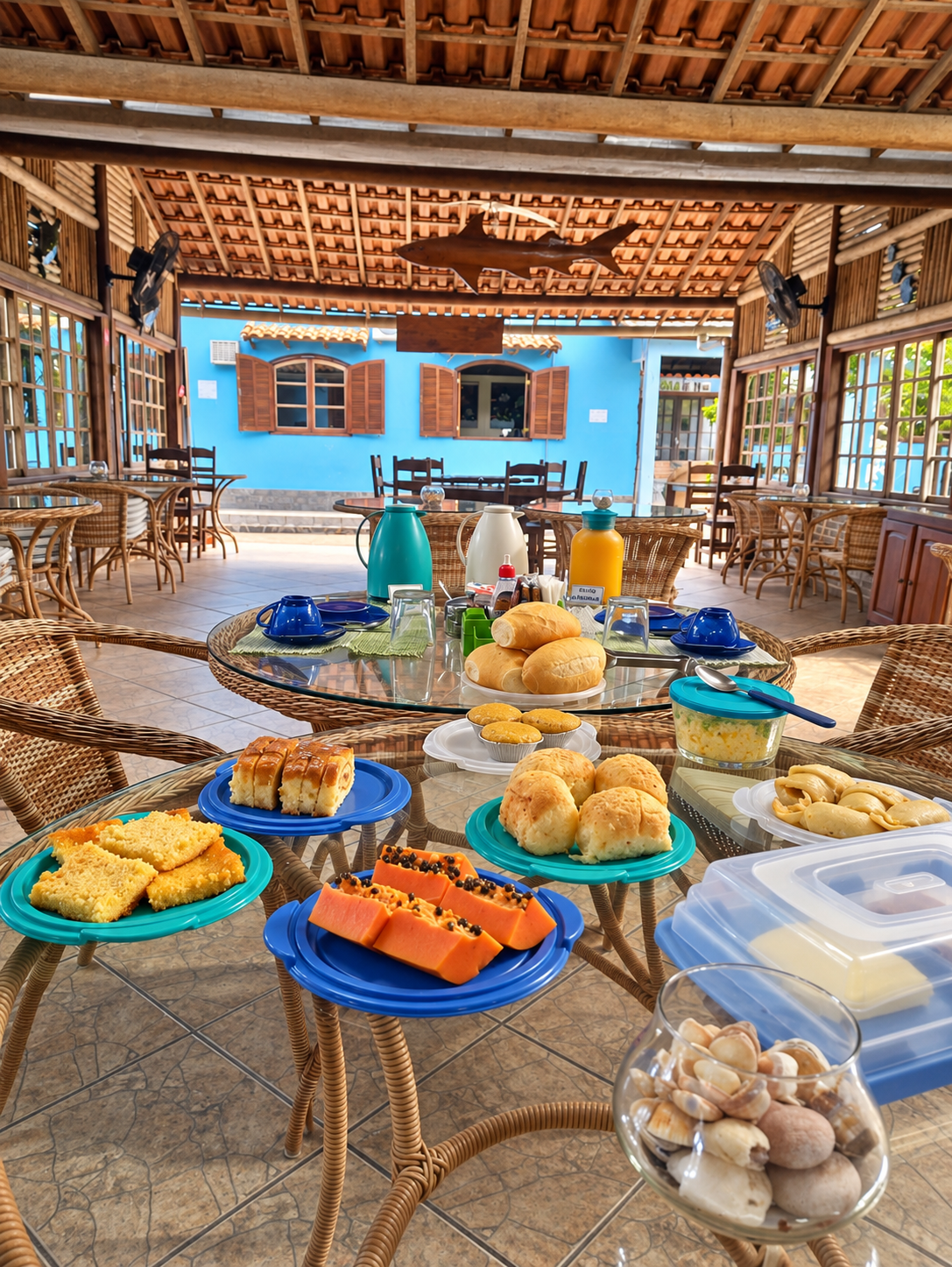 Mesa de café da manhã na área coberta da pousada
